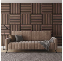 Vardagsrum med soffa, kuddar, filt, lampa, matta och väggpaneler