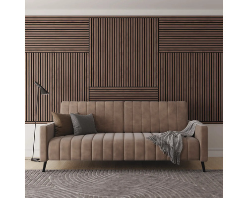 Vardagsrum med soffa, kuddar, filt, lampa och träpanelvägg