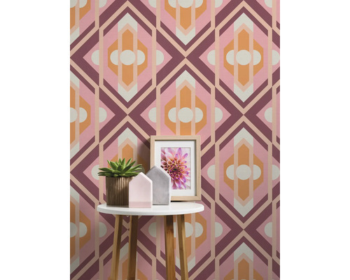 Rumsöversikt med geometrisk tapet, sidobord, krukväxt och fotoram