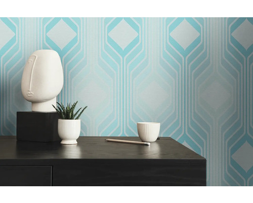 Rum med geometrisk tapet, växt och dekoration på ett bord