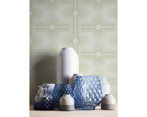 Arrangemang av olika vaser framför en mönstrad tapet