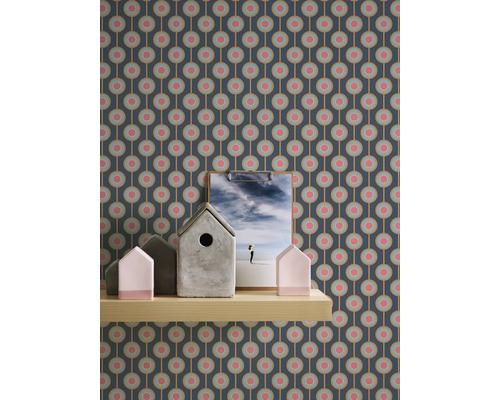 Tapet med grafiskt cirkelmönster bakom en hylla med dekoration