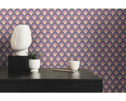 Närbild av en vägg med retro tapet i lila och brunt, med bord, dekoration och växt