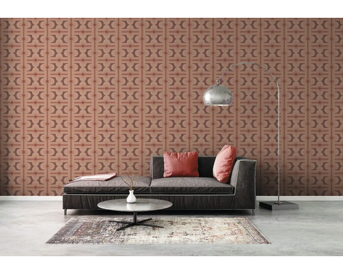 Vardagsrum med mönstrad tapet, soffa och golvlampa.