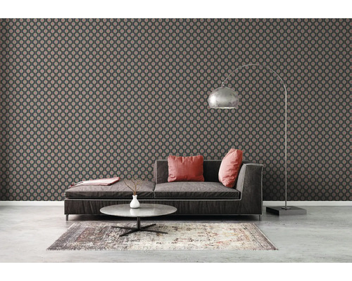 Vardagsrum med modern mönstrad tapet, soffa och golvlampa