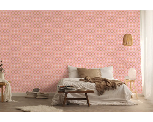 Sovrum med rosa prickig tapet, säng och nattduksbord