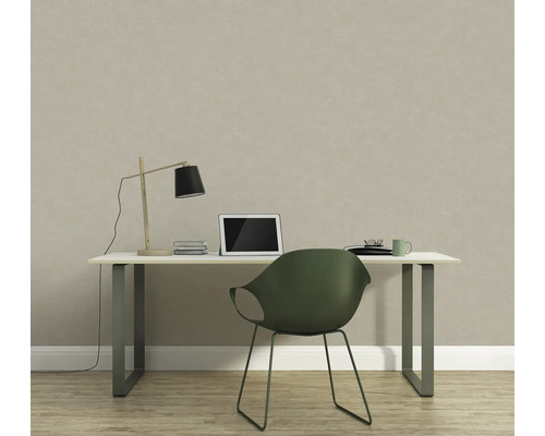 Arbetsrum med skrivbord, lampa, bärbar dator och stol framför en strukturerad tapet