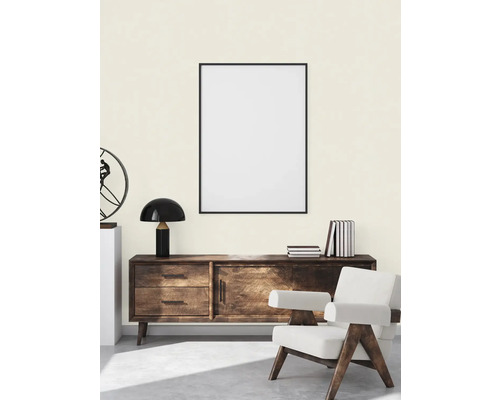 Ljust rum med byrå, fåtölj och inramad bild