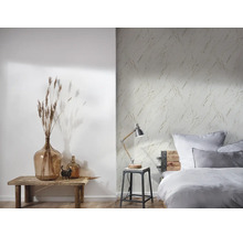 Sovrum med säng, lampa och en vägg med marmortapet