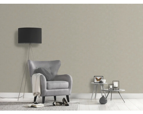 Vardagsrum med beige strukturtapet, fåtölj och golvlampa