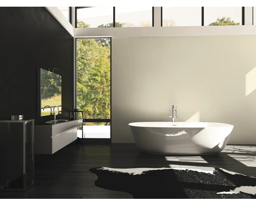 Badrum med fristående badkar, tvättställ och stort fönster