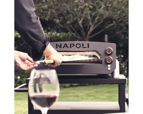 Napoli pizzaugn med pizzaspade på ett bord med ett glas vin i förgrunden