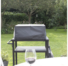 Övertäckt grill på en terrass i en trädgård.
