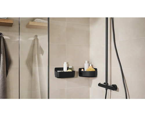 Badrum med dusch, handdukar och två svarta duschkorgar för förvaring av badrumsartiklar