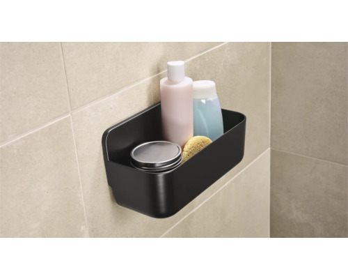 Svart badrumshylla med toalettartiklar på väggen
