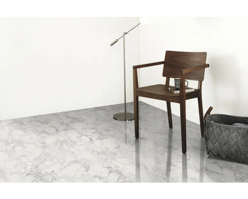 Ljust rum med golv i marmorlook, trästol, golvlampa och korg