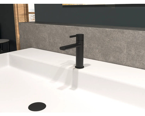 Svart tvättställsblandare på ett vitt tvättställ