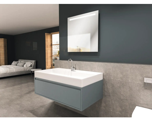 Badrum med tvättställ, spegel och säng