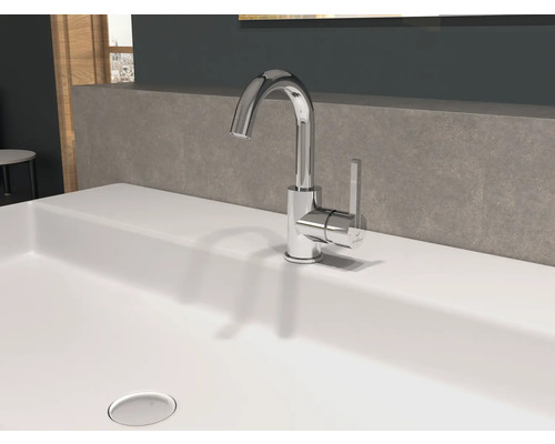 En glänsande kran står på ett handfat.