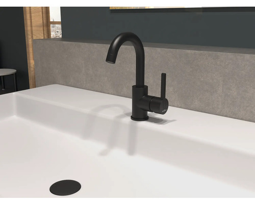 Svart tvättställsblandare på ett vitt tvättställ