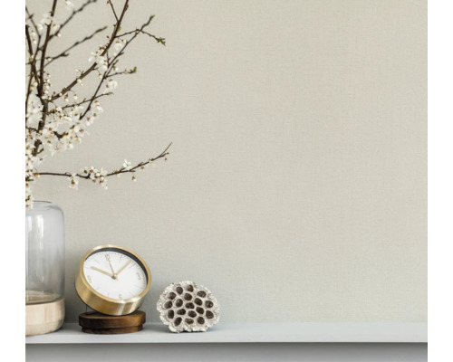 Närbild av en vägg med klocka, dekoration och vas med blommor