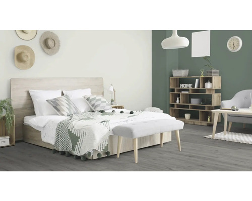 Ljust sovrum med säng, nattduksbord, hylla och bänk