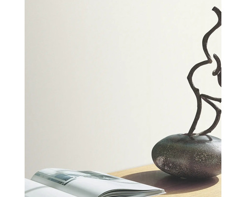 Ljust rum med bok, dekoration och vas på ett bord