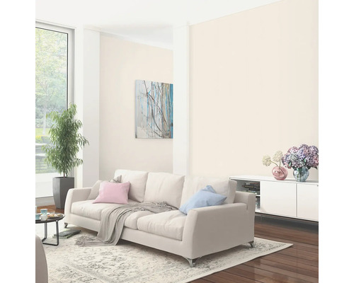 Ljust vardagsrum med soffa, matta, krukväxt och konstverk för inredningsidéer