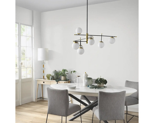 Matbordscen med en modern hänglampa med flera glaskulor.