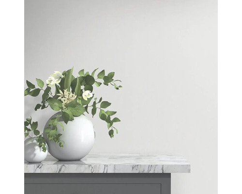 Dekorativt arrangemang med blommor i runda vaser på ett bord med marmorskiva