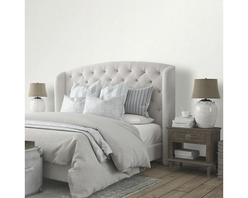 Sovrum med säng, sängbord och lampor för en ljus och organiserad atmosfär.