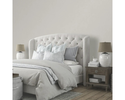 Sovrum med säng, sängbord och lampor i neutral design