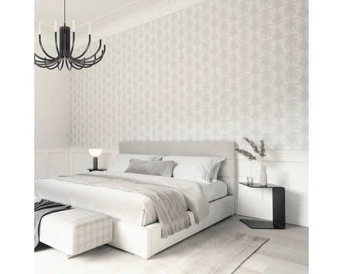 Sovrum med dubbelsäng, sängbord och mönstrad tapet