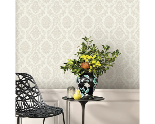 Scen med mönstrad tapet, bord med blomvas och stol