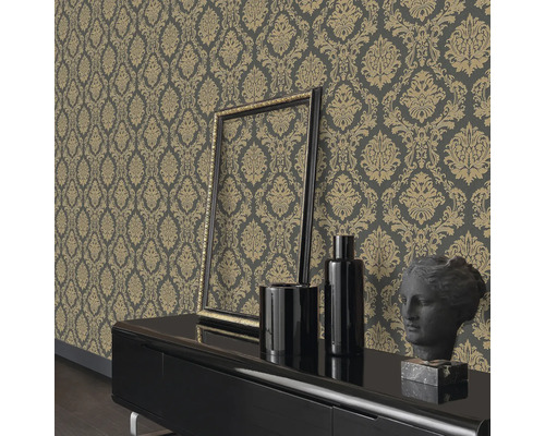 Vardagsrum med mönstrad tapet, ram, vaser och en byst på ett skåp