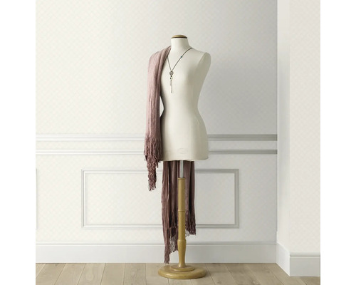 Ljus tapet med rombmönster i rum med skyltdocka och sjal