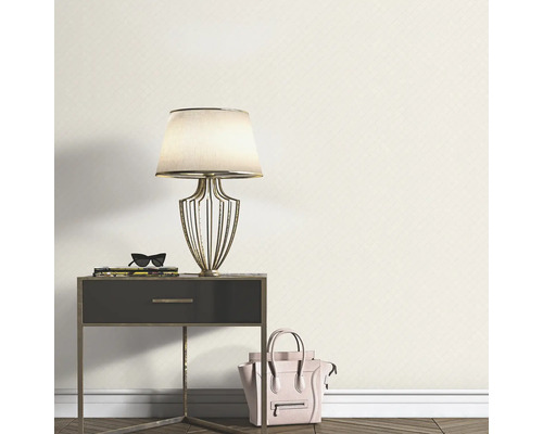 Miljöbild med sängbord, lampa, dekoration och mönstrad tapet