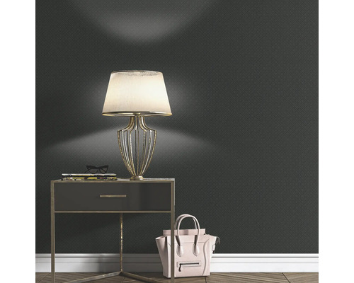 Vardagsrum med mönstrad tapet, sänglampa och handväska