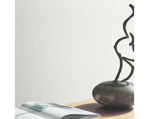 Ljus tapet med träutseende på en bordsdekoration med bok och skulptur