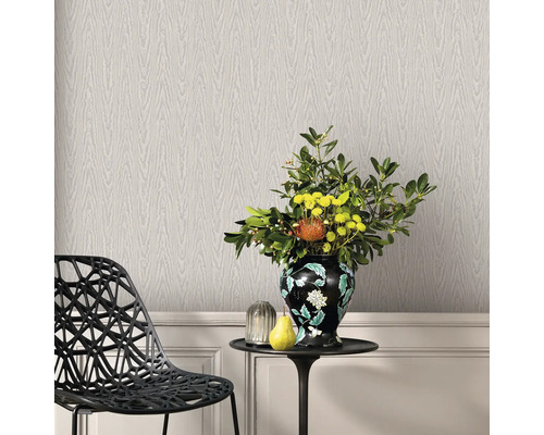 Dekorativ interiör med tapet i trälook, stol och bord med blomvas.