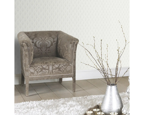 Dekorativ interiör med fåtölj, silverfärgad vas och mönstrad tapet