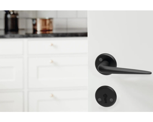 Svart dörrhandtag framför köksinredning