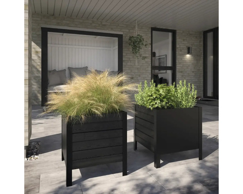 Två svarta planteringslådor med växter på en terrass