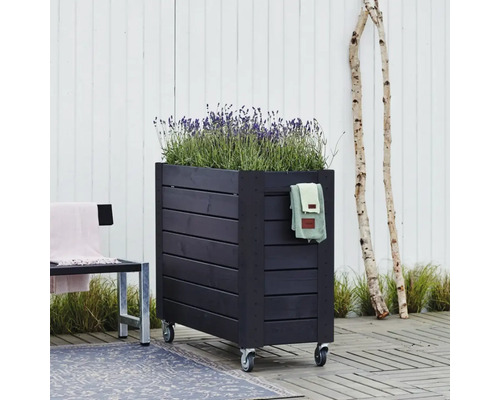 Mörk träplanteringslåda med hjul och lavendel på en terrass