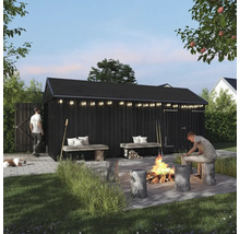 Svart redskapsbod med belysning, eldstad och sittplatser i trädgården