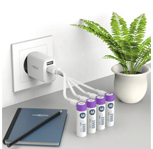 Laddare med fyra AA-batterier, anteckningsbok och penna på ett bord