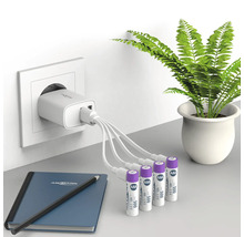 Laddare med flera AAA-batterier, anteckningsblock och penna på ett bord