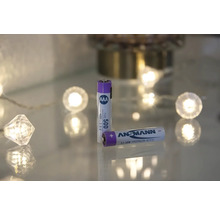 Två Ansmann AAA-batterier ligger på en glasytan