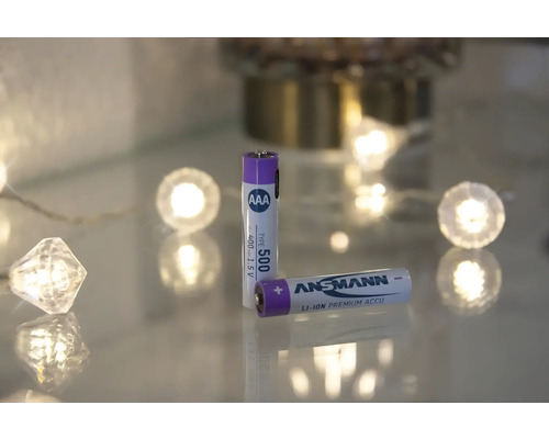 Två Ansmann AAA-batterier ligger på en glasytan