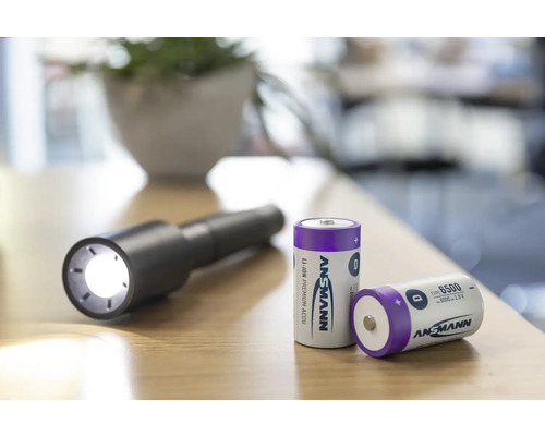 Ansmann logotyp med Ansmann batterier och en tänd ficklampa